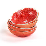 Stack of grapefruit shaped ceramic bowls with a textured surface on a white background