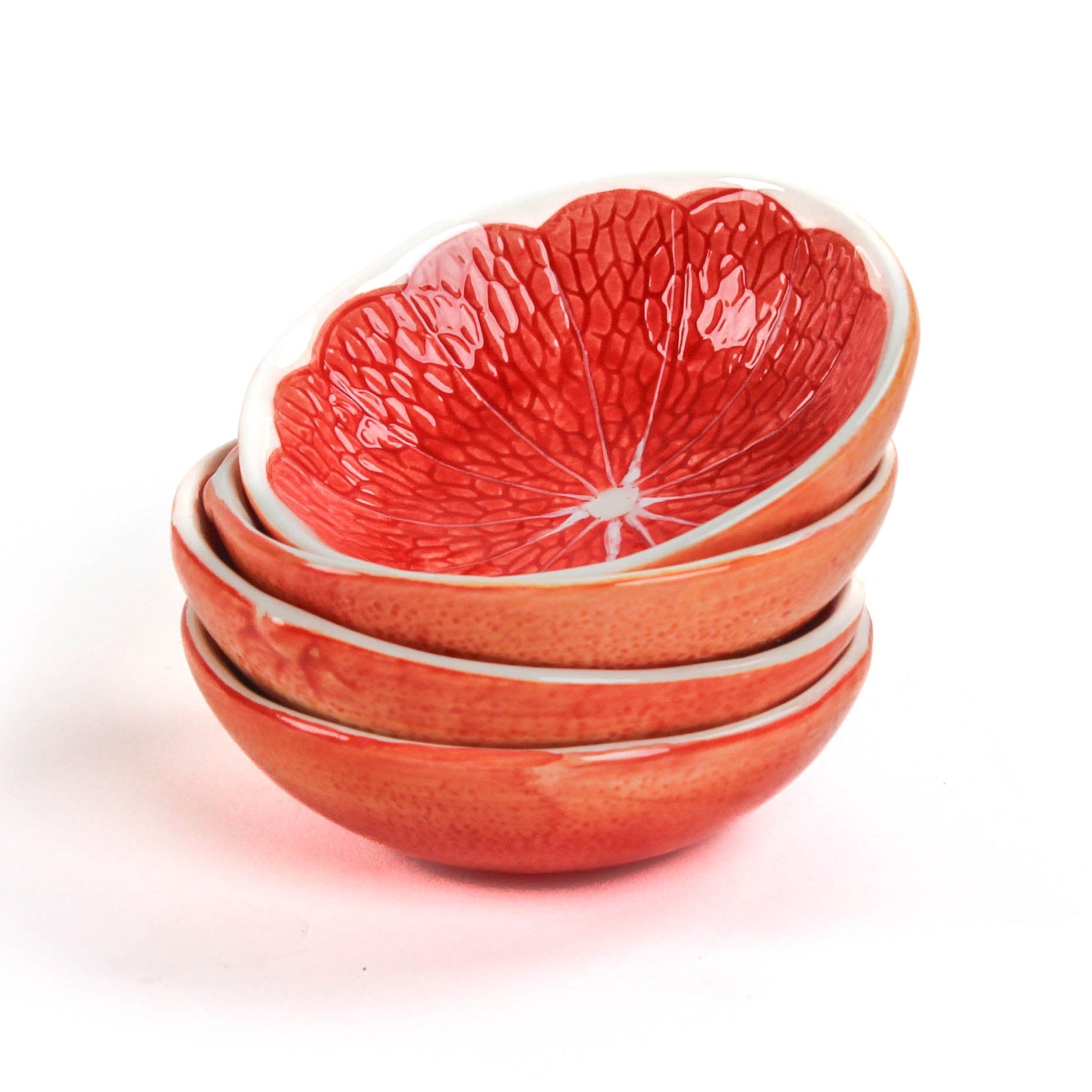 Stack of grapefruit shaped ceramic bowls with a textured surface on a white background