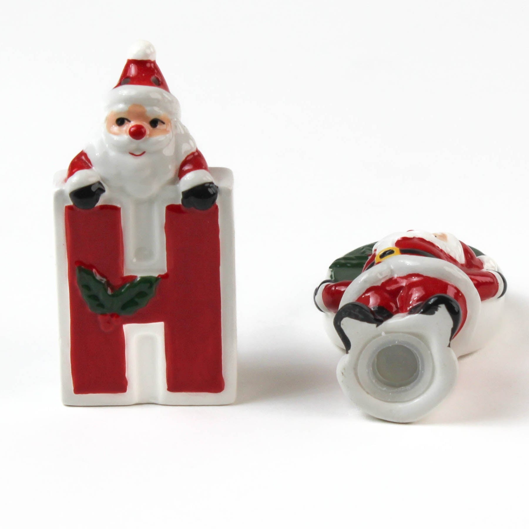 Two ceramic christmas salt and pepper shakers shaped like the letters 'H' and 'O' with Santa Claus figures on a white background.