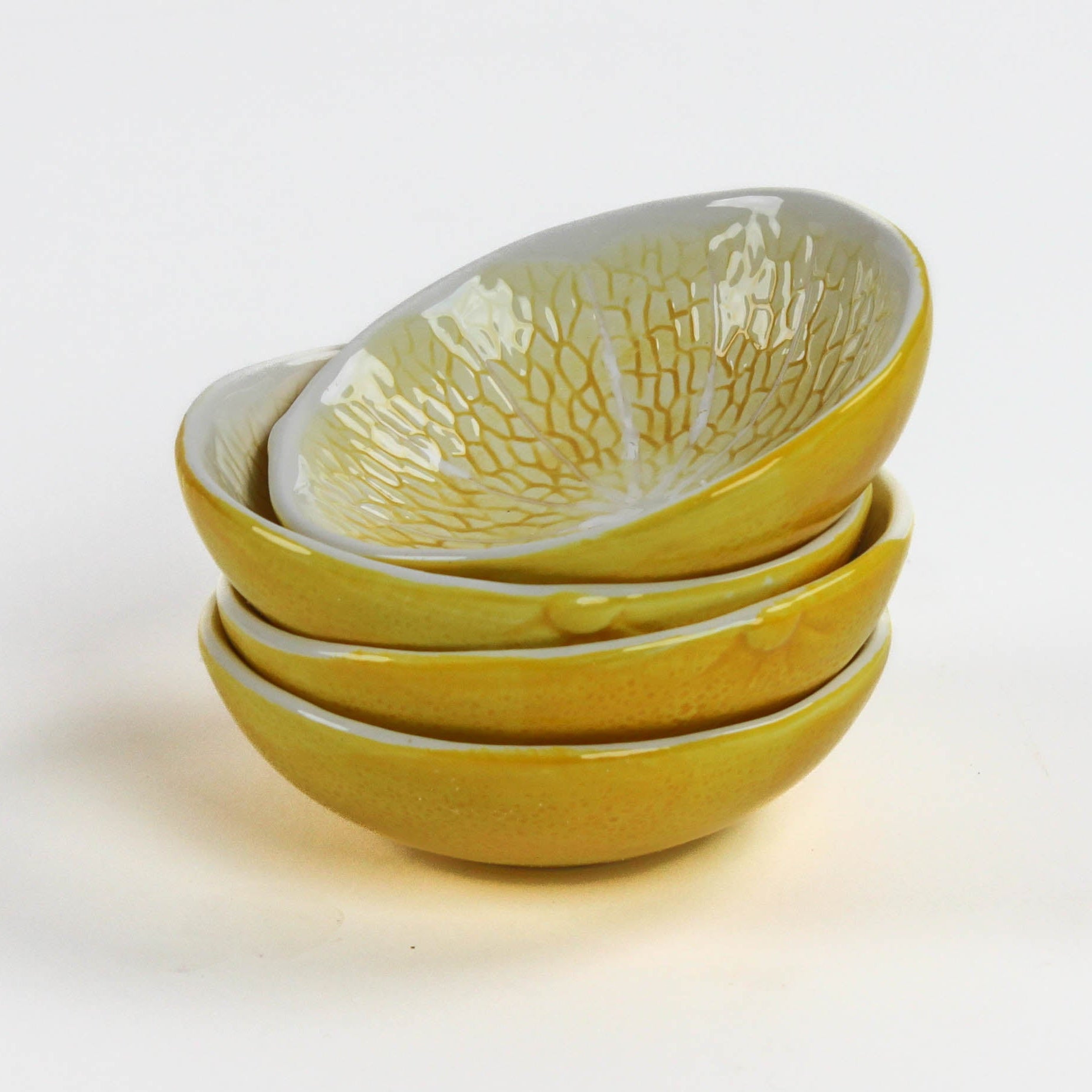 a set of four stacked lemon shaped bowls