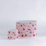 Two metal containers with pink nutcracker patterns on a white background