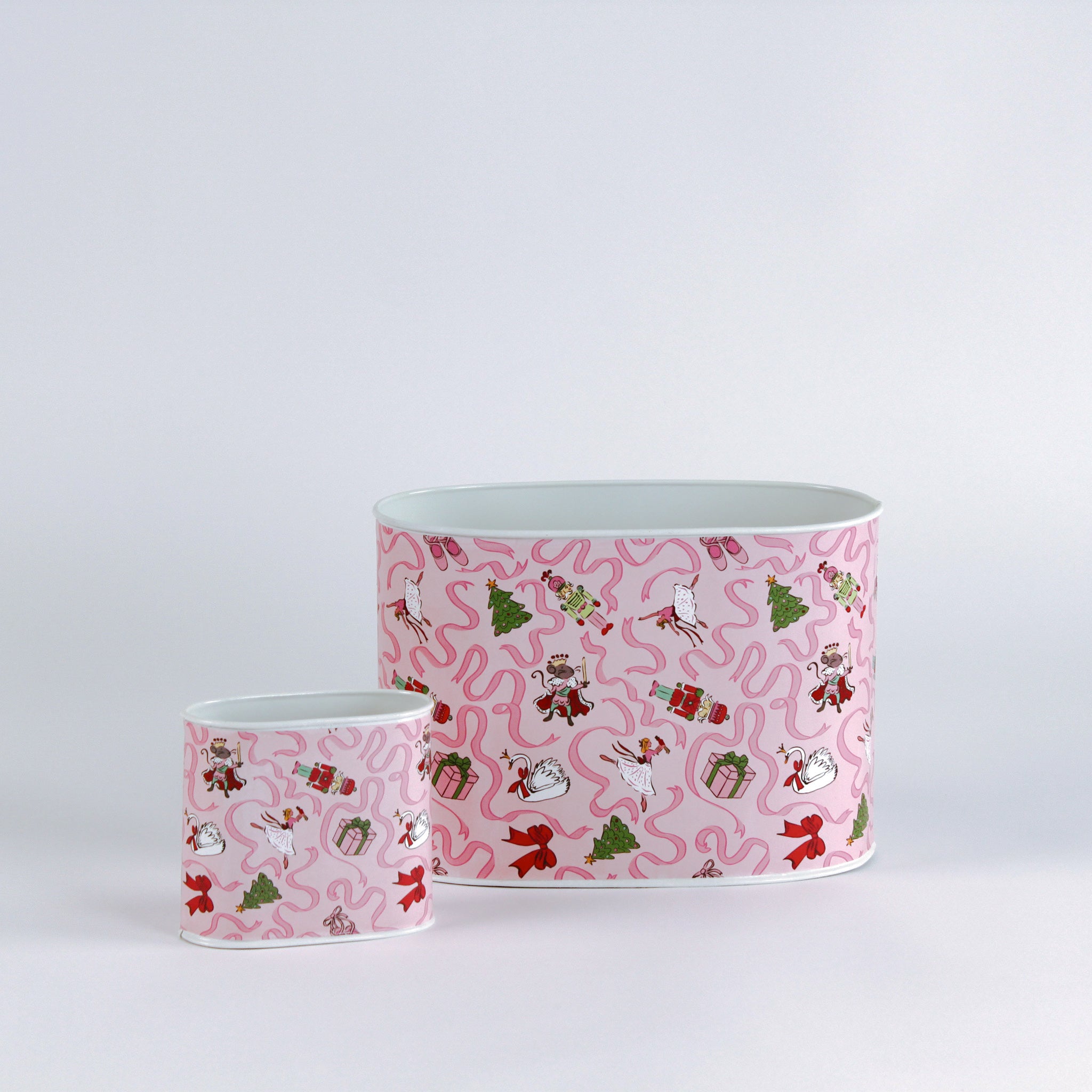 Two metal containers with pink nutcracker patterns on a white background