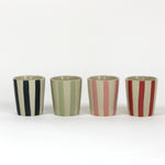 A set of four striped ceramic cups in black, green, pink and red