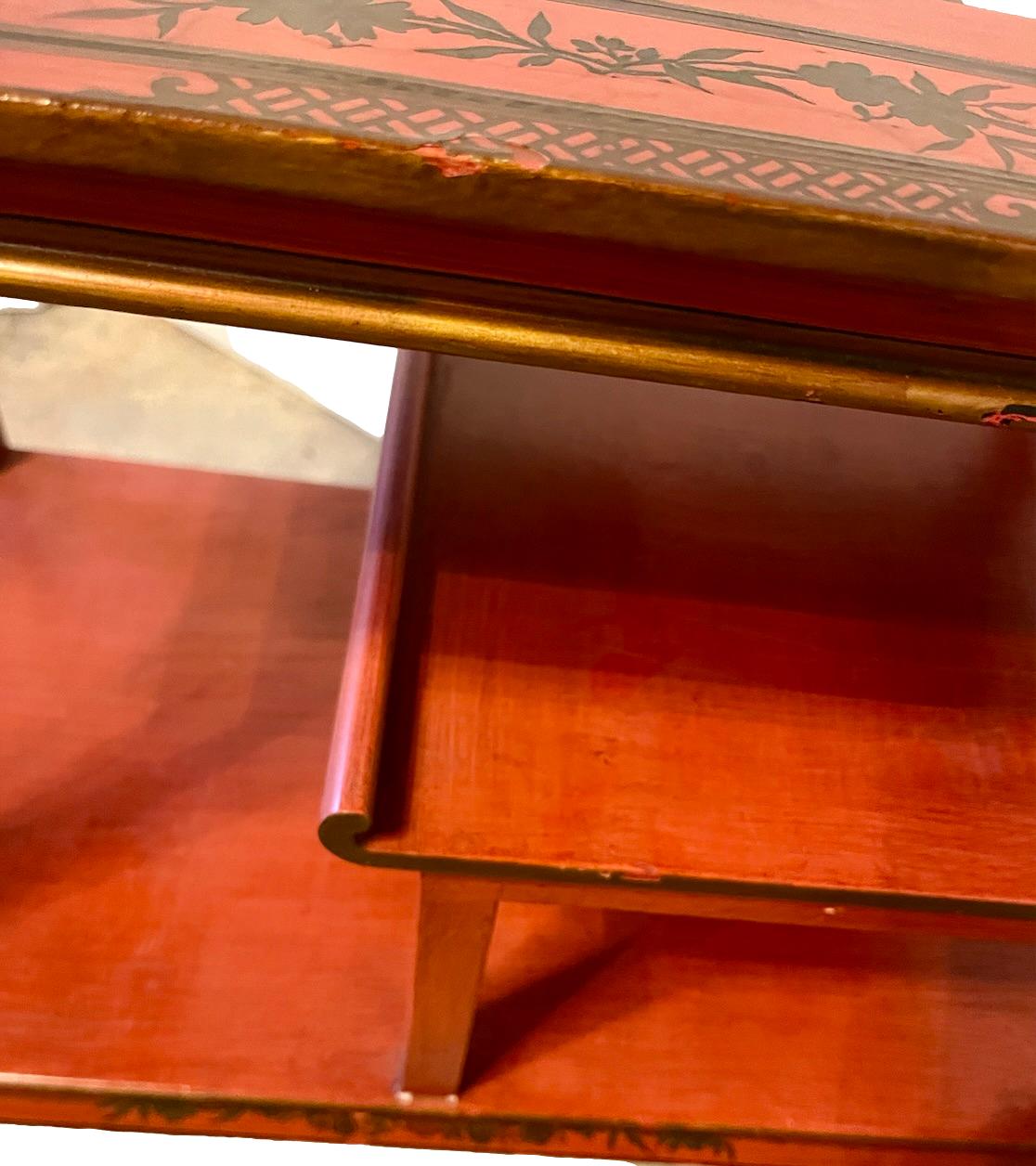 a dark wood chinoiserie side table with two tiers and on rolling casters.