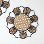 Decorative woven rattan placemat with shell patterns on a white background