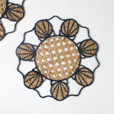 Decorative woven rattan placemat with shell patterns on a white background