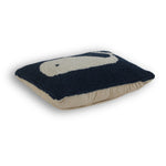 the side angle of a blue and white whale pillow against a white background. 
