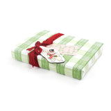 Wrapped gift in green gingham Christmas paper with red ribbon and festive tag.