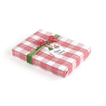 Gift wrapped in red and white gingham paper with green ribbon and Christmas gift tag.