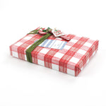 Gift wrapped in red and white gingham paper with green ribbon and Christmas gift tag.