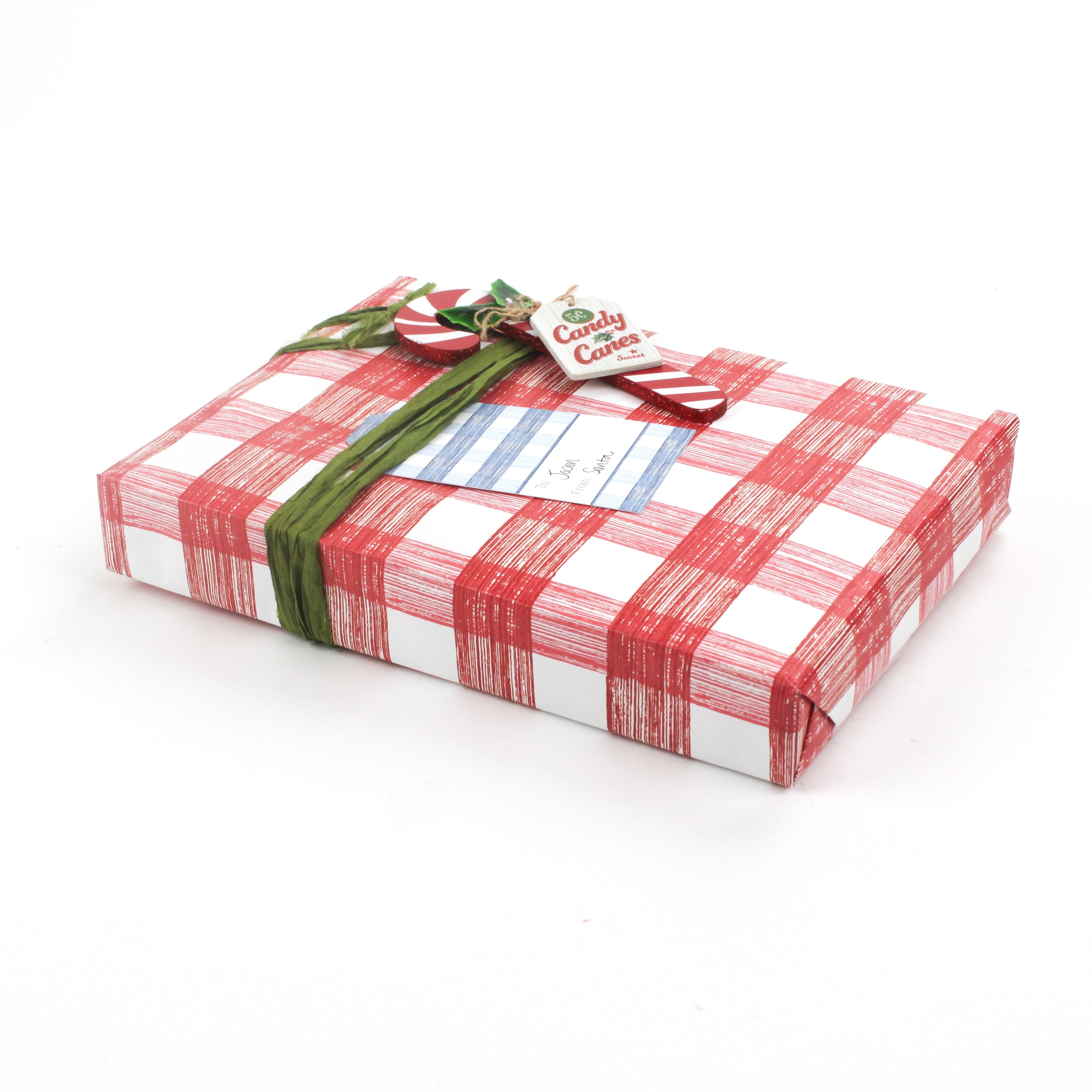 Gift wrapped in red and white gingham paper with green ribbon and Christmas gift tag.