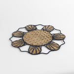 Decorative woven rattan placemat with shell patterns on a white background