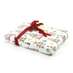 Side view of gift wrapped in pagoda Christmas print paper with red ribbon and green gift tag.