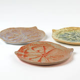 three citrus fruit shaped ceramic plates with decorative citrus patterns on a white background