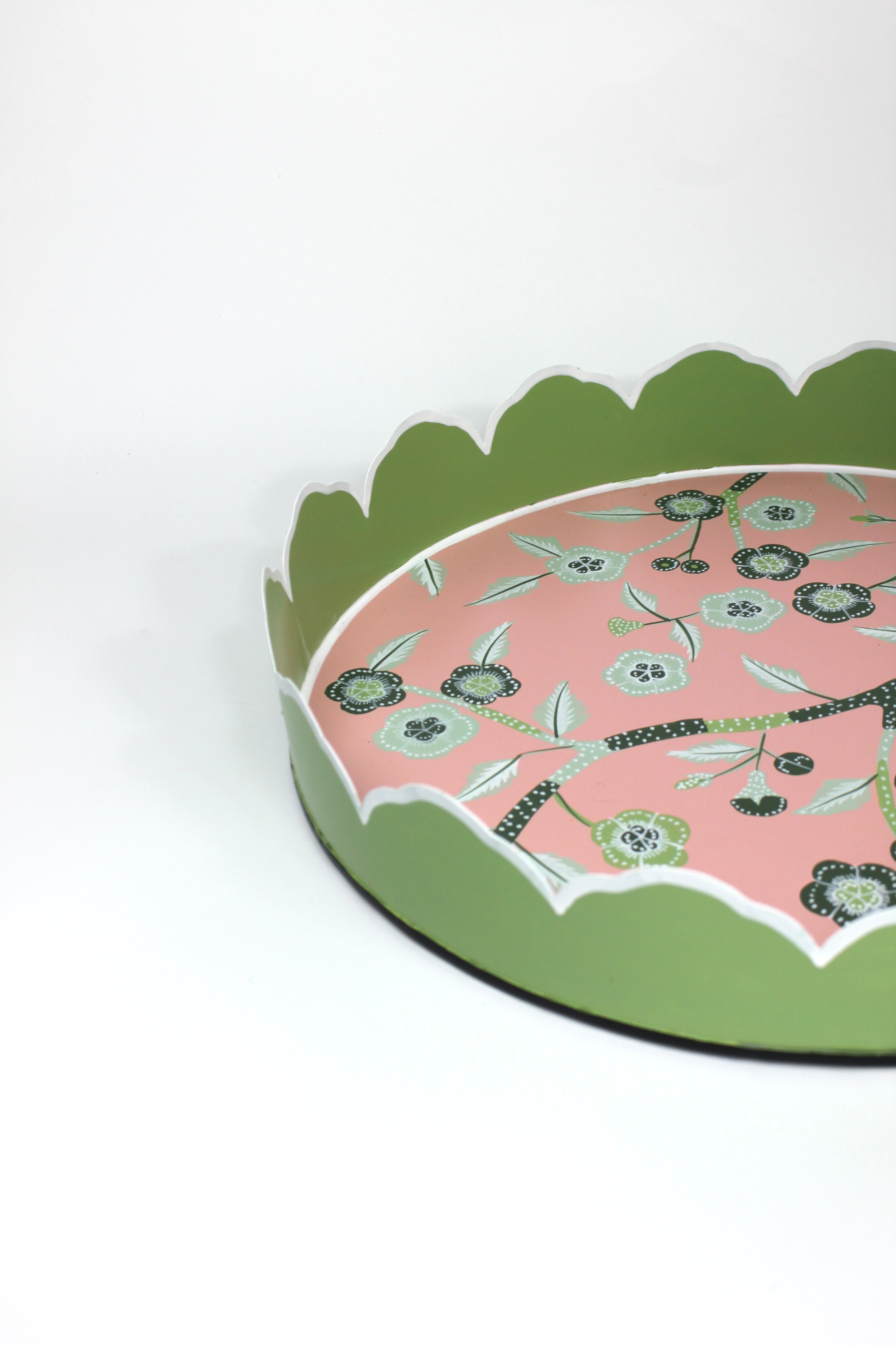 Side detail view of Temple Garden, a tole metal tray with scalloped edges in green with a pink and green chinoiserie peony blossom pattern
