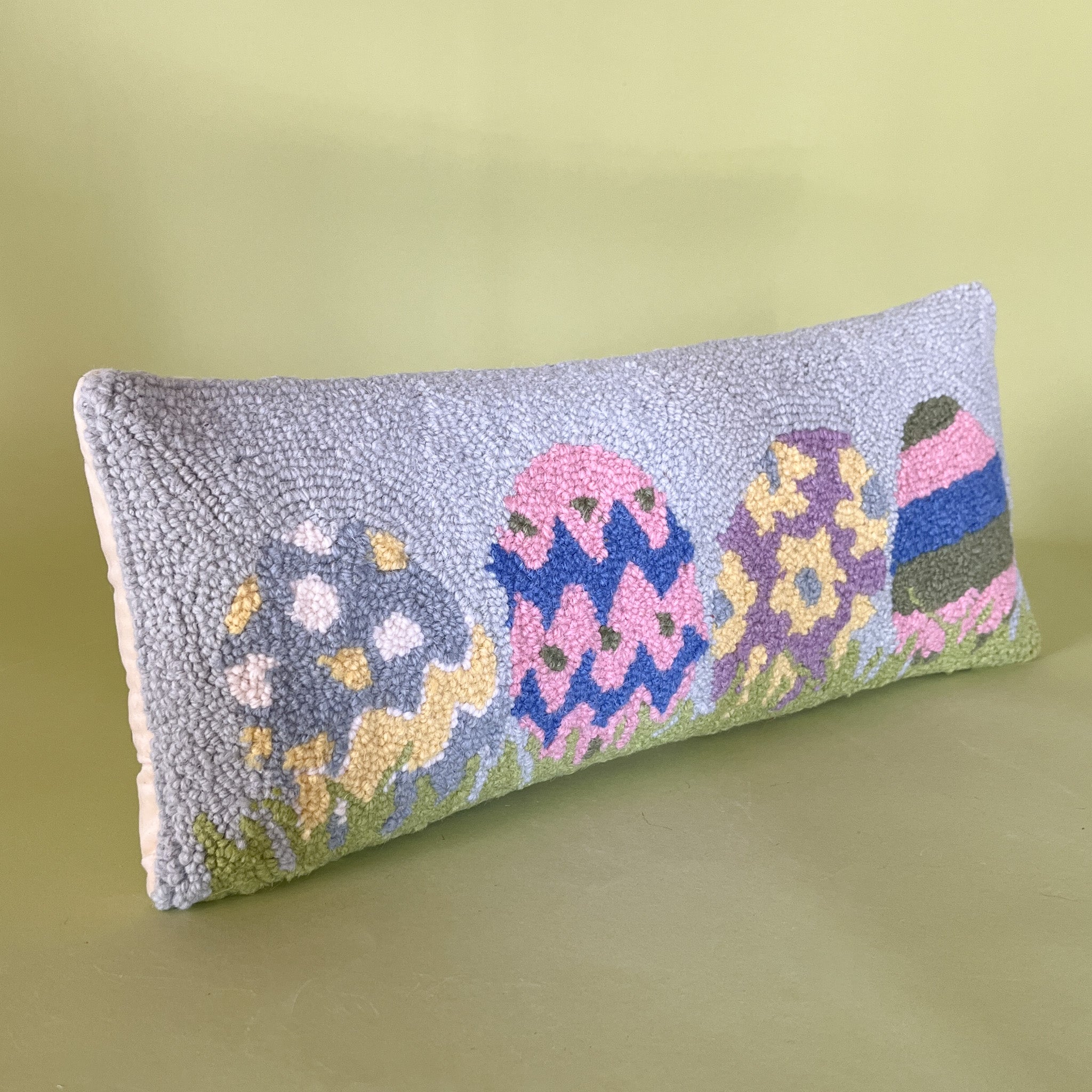 side view of a Purple easter pillow with four easter eggs.