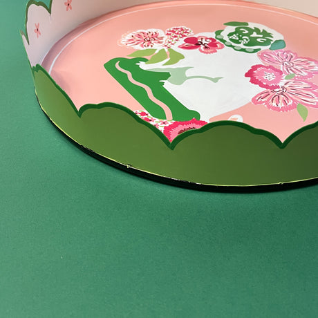 the green scalloped edge of a pink tole tray