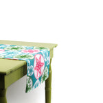 Side view of a colorful snowflake-patterned table runner draped over a green table.