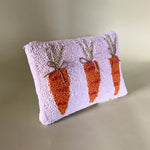 A white easter pillow with three orange carrots