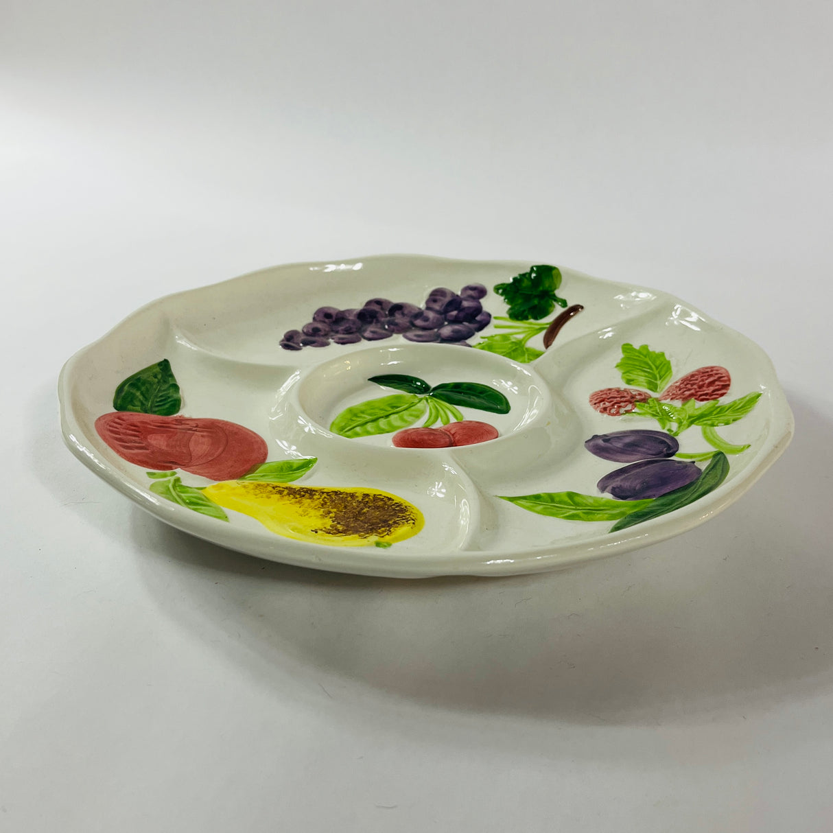 A white vintage strawberry pitcher with strawberry motifs decorating the side