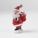 santa table decoration of santa holding a candy cane in a red sack on a white background