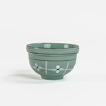A small light green ceramic christmas bowls against a white background. 