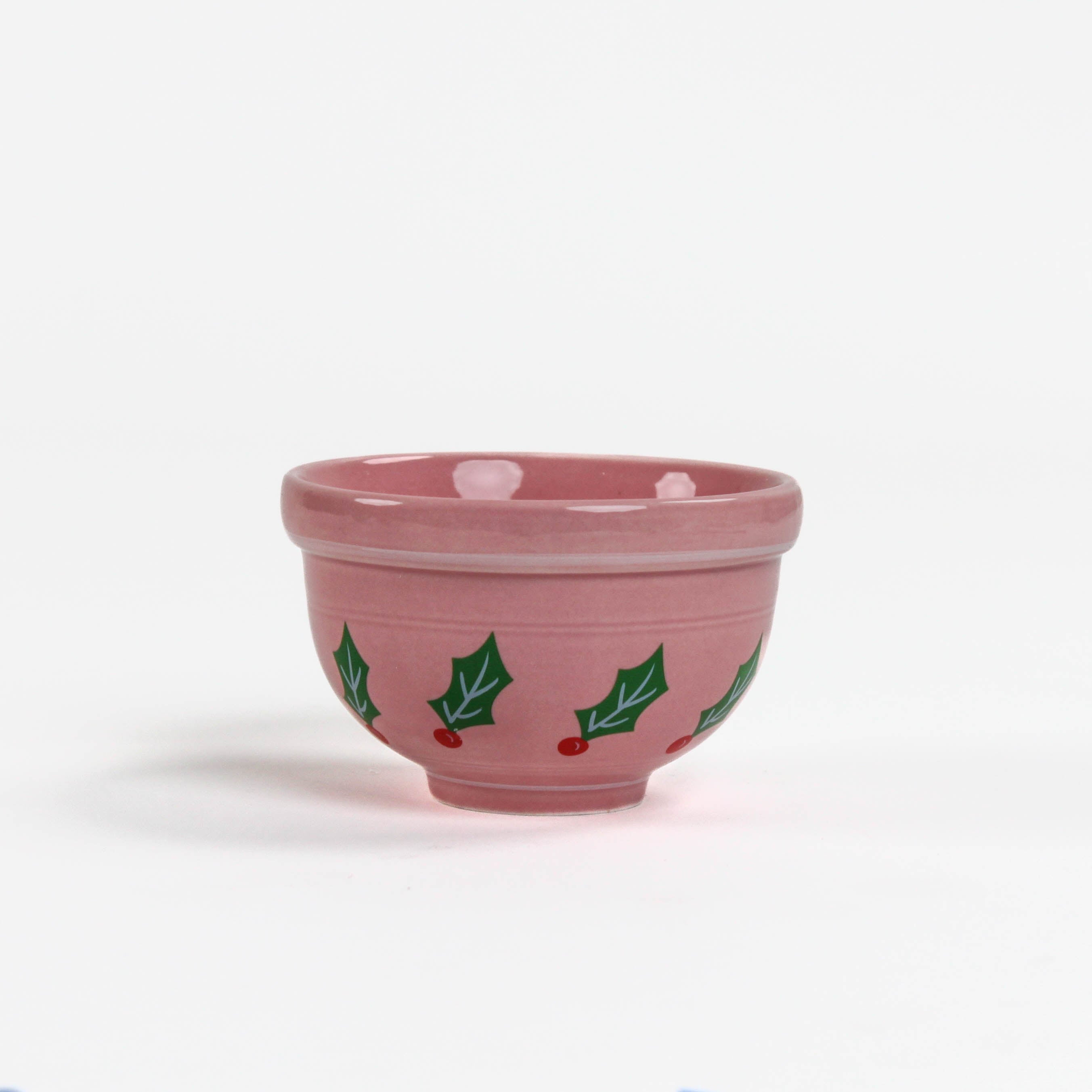A small pink ceramic christmas bowls against a white background. 