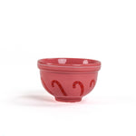 A small red ceramic christmas bowls against a white background. 