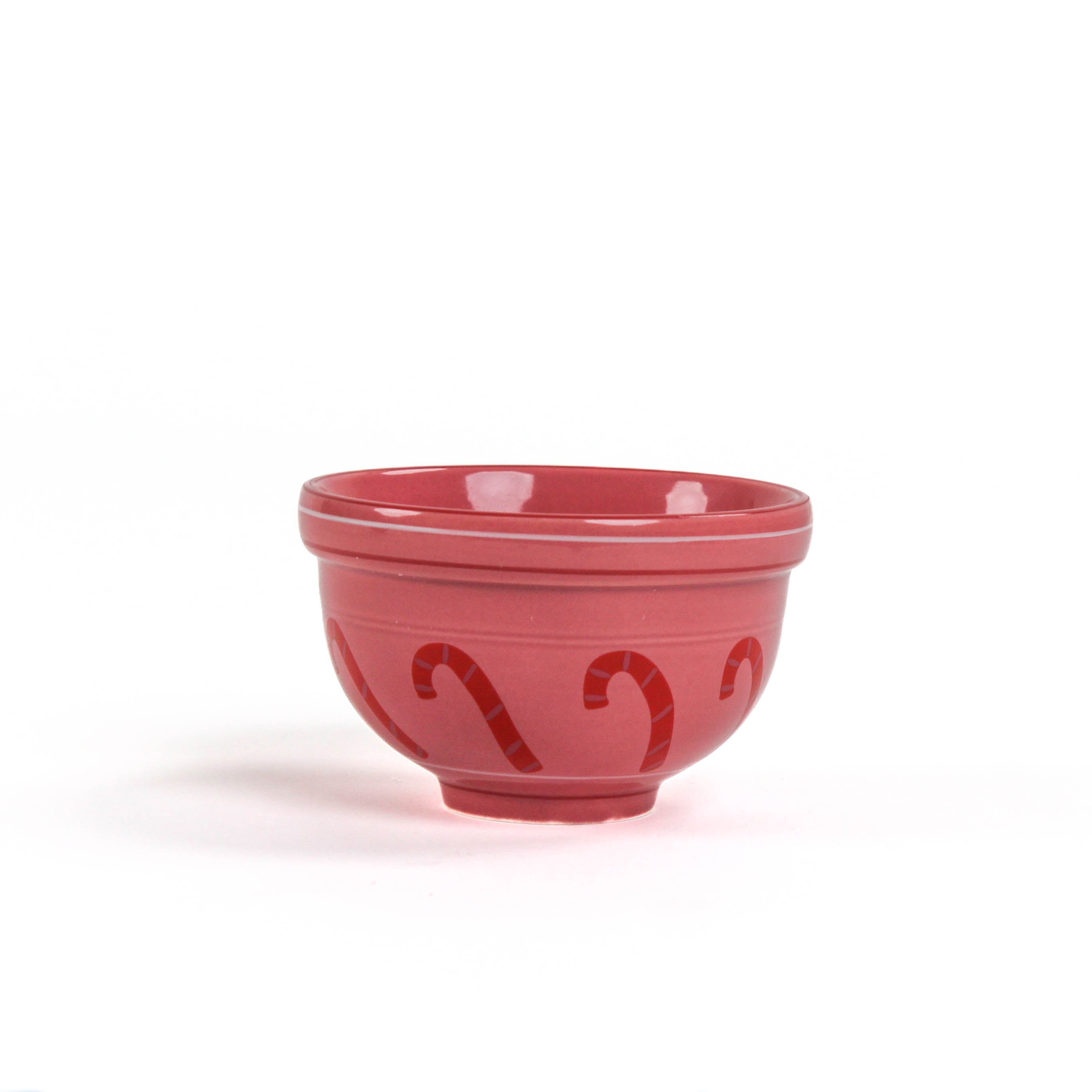 A small red ceramic christmas bowls against a white background. 