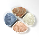 a small ceramic shell bowl set featuring four shells in blue, brown, pink and white