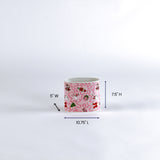 Small pink container with christmas nutcracker pattern and measurements on a white background