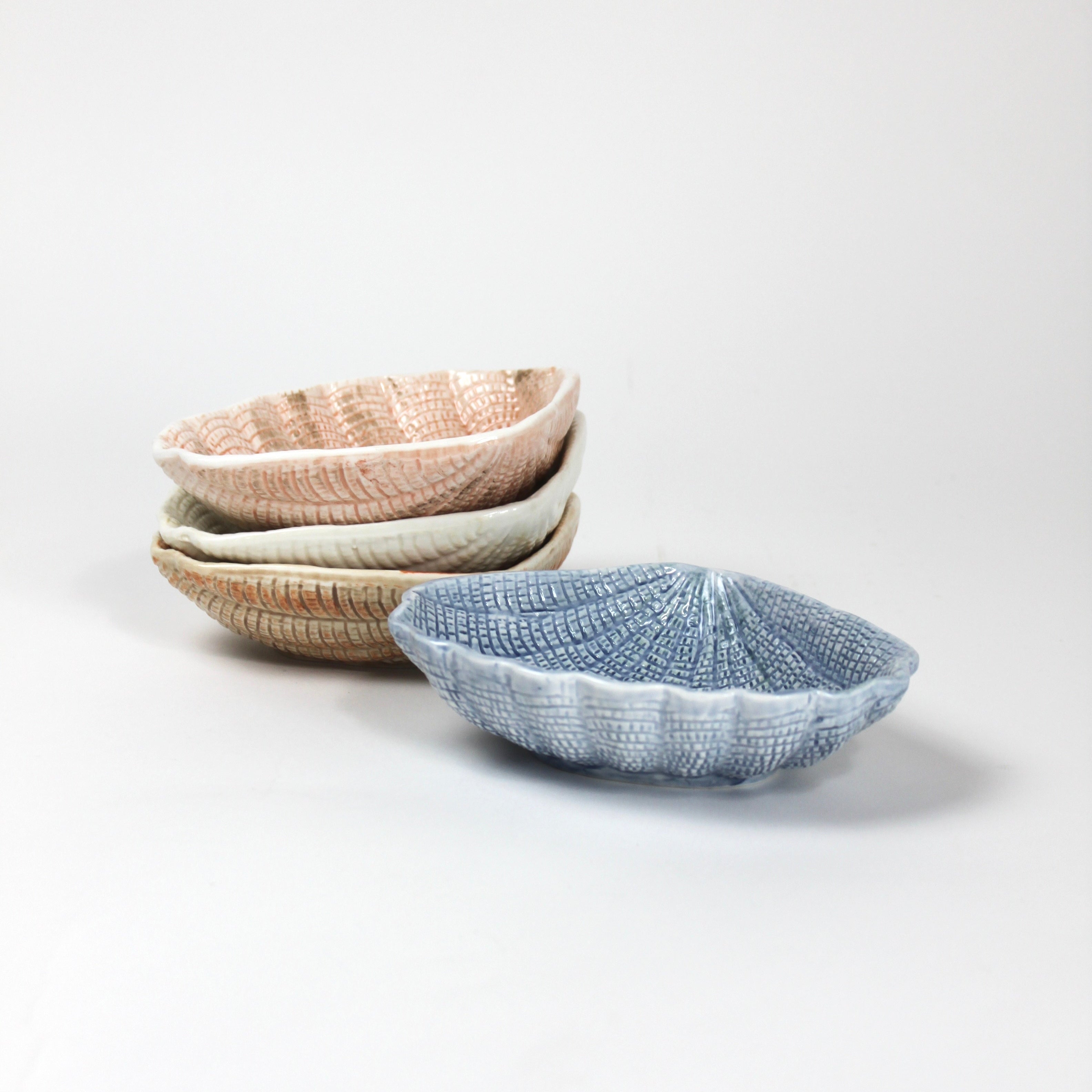 a set of blue, brown, white and pink ceramic shell bowls