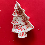 a small red and white christmas tree shape vintage plate on a red background. 