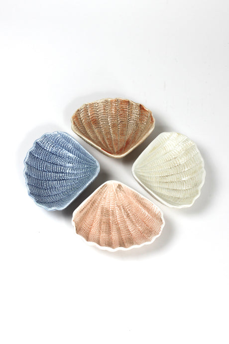 a small ceramic shell bowl set featuring four shells in blue, brown, pink and white