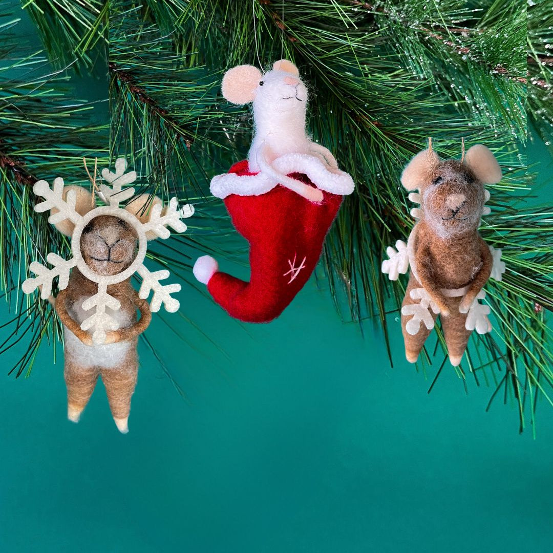 Three small felt mice christmas ornaments hanging on a green pine branch