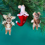 Three small felt mice christmas ornaments hanging on a green pine branch