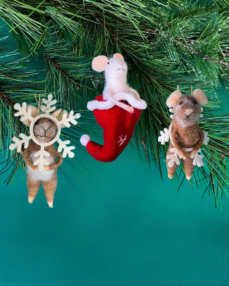 Three small felt mice christmas ornaments hanging on a green pine branch