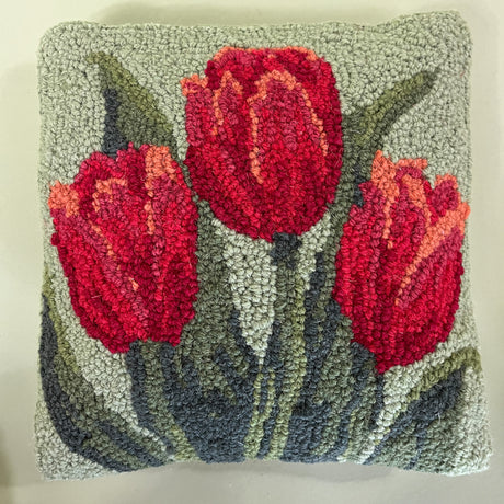 up close picture of green spring pillow with red tulips