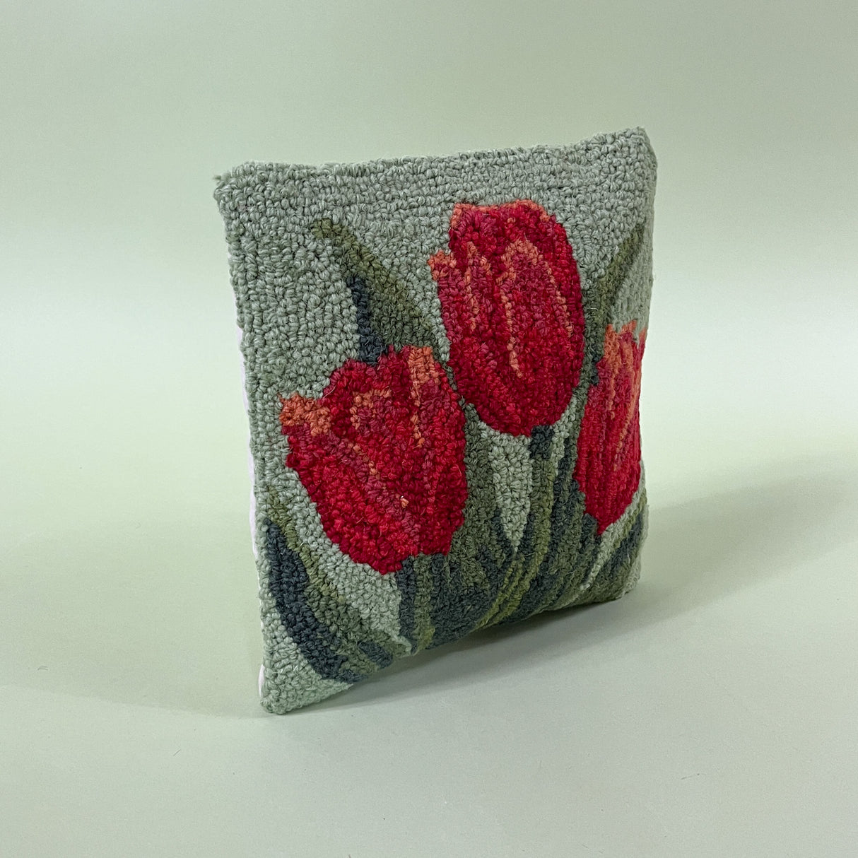 green spring pillow with red tulips side view