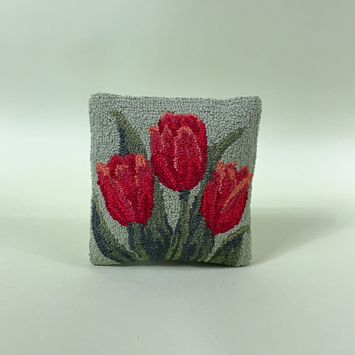 green spring pillow with red tulips