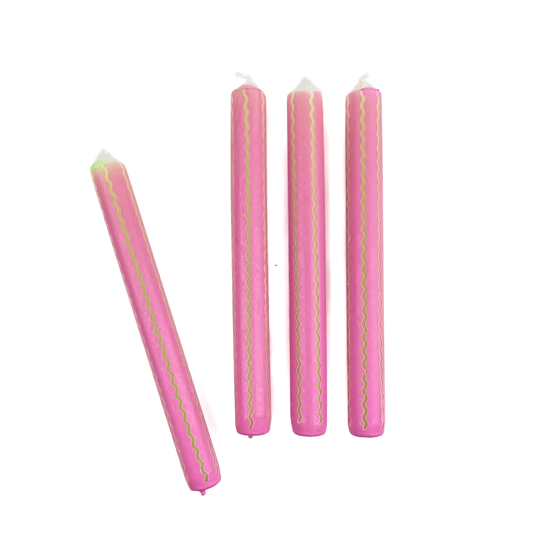 Pink taper candles with green squiggle stripe detailing arranged as a set for spring table decor.