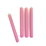 Pink taper candles with green squiggle stripe detailing arranged as a set for spring table decor.