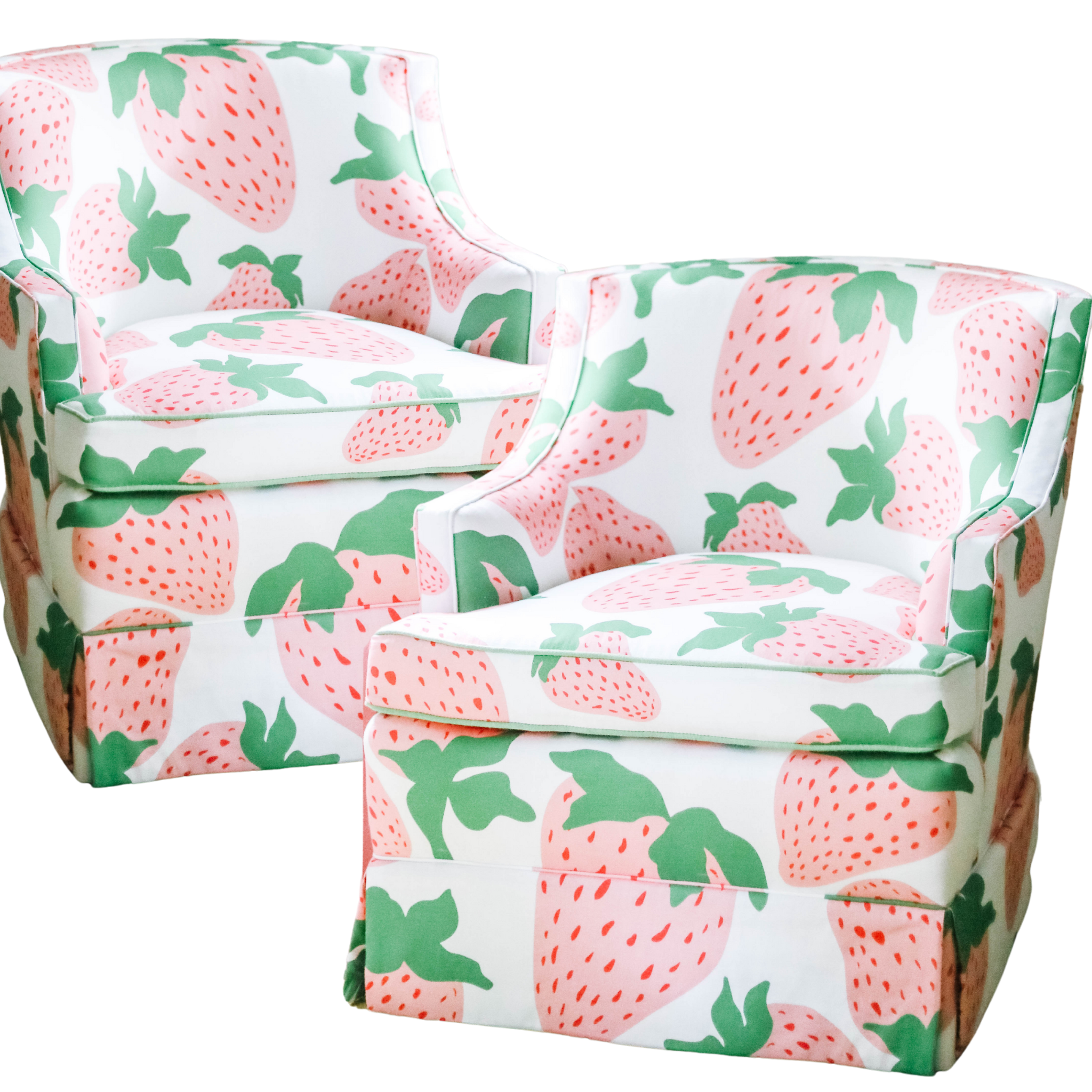 a pair of upholstered armchairs covered in strawberry fabric featuring large pink strawberries.