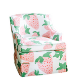 a small upholstered chair covered in strawberry fabric featuring large pink strawberries with green leaves.