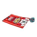 a striped christmas tea towel with four nutcracker motifs and blue and pink tasseled corners.