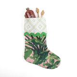 A palm leaf print pink and green Christmas stocking on a white background