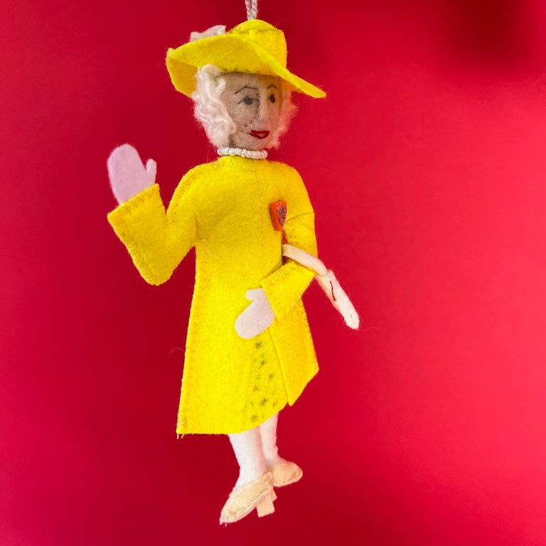Decorative ornament of Queen Elizabeth in a yellow outfit on a red background