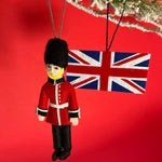 Decorative ornament of a British guard with a Union Jack flag on a red background