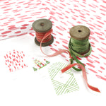 Styled display of pink brushstroke wrapping paper with ribbons and gift tags.