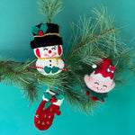 Handcrafted Holiday Icons Felt Christmas Ornaments featuring elf, snowman, and mitten designs in festive red, green, and white colors.